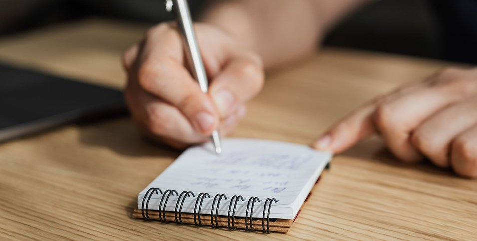 En person antecknar i ett anteckningsblock