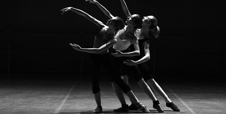 En svartvit bild med tre tjejer som dansar balett.